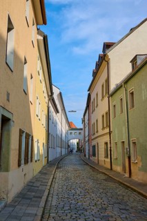 Narrow alley with cobblestones lined with colourful houses under a clear sky, Waffnergasse,