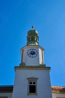 Historic clock tower against a bright blue sky. Baroque architecture with clear lines, brewhouse am