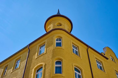 Yellow building with round tower and windows in front of a clear sky, Regensburg, Bavaria, Germany