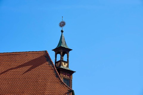 Historic rooftop with tower and weather vane under a clear sky, Regensburg, Bavaria, Germany