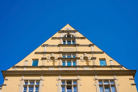 Building with striking triangular gable and windows against a clear sky, Regensburg, Bavaria,