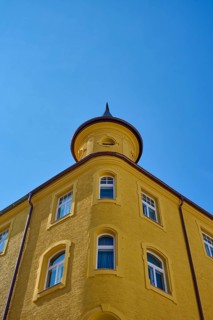 Yellow building with round tower and windows in front of a clear sky, Regensburg, Bavaria, Germany