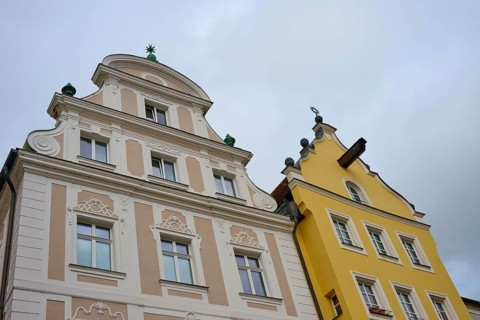 Detailed view of decorated facades of historic buildings under a cloudy sky, Regensburg, Bavaria,