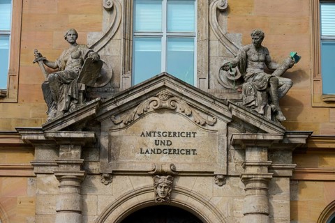 Historic façade of a court building with decorative sculptures and classical architecture, district