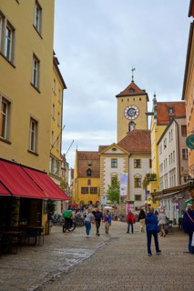 Lively pedestrian zone with a view of the tower, surrounded by historic buildings, Regensburg,