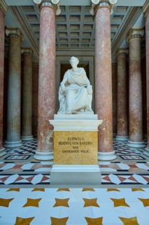 White statue of Ludwig I, surrounded by red marble columns and magnificent floor pattern, Walhalla,