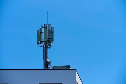 Communication tower on the roof of a building under a clear blue sky, Regensburg, Bavaria, Germany