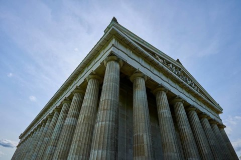 Impressive towering columned building in front of a blue sky in low perspective, Walhalla,