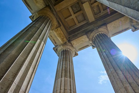 Three massive columns rise up against the blue sky, seen from below, Walhalla, Donaustauf,