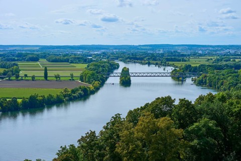 A tranquil river landscape with bridge and trees under a cloudy sky, Walhalla, Donaustauf, Danube,