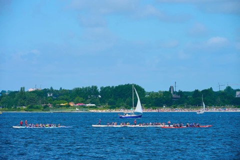 Canoeist and sailing boat on the sea in sunny weather, Heikendorf, Plön district, Kiel Fjord,