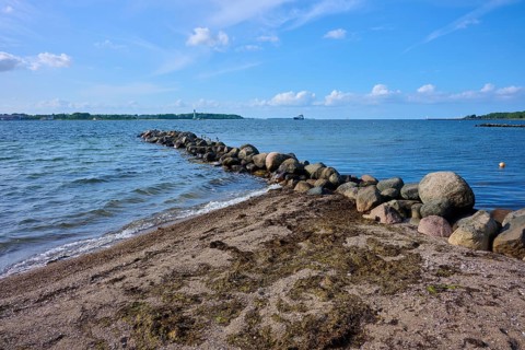 Stone breakwater in the sea on a sunny beach day with blue sky, Heikendorf, Plön district, Kiel