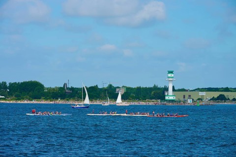 Scene at the sea with several boats and a lighthouse in the background, lighthouse Friedrichsort,