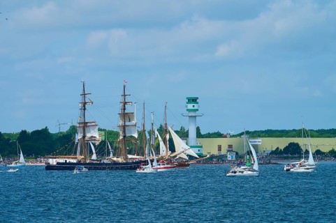 Large traditional sailing ship surrounded by sailing boats on the sea near Friedrichsort