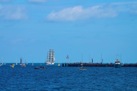 A sailing ship Gorch Fock in the distance, various boats and a jetty in the picture, Windjammer