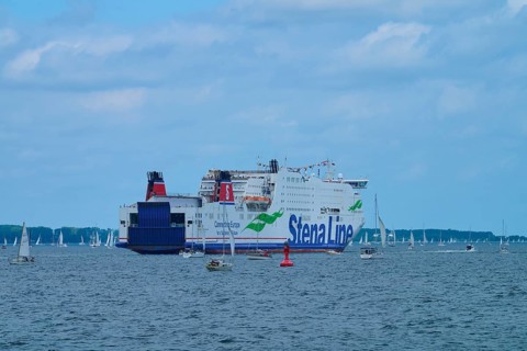 Large ferry on the sea surrounded by sailing boats under a blue sky, Windjammer Parade Kiel 2025,