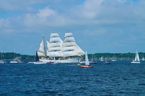 A tall ship Gorch Fock on the sea between several other boats, Windjammer Parade Kiel 2025,