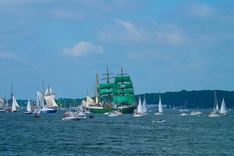 Beautiful view of many sailing boats and a striking green sailing ship Alexander von Humbold 2 in