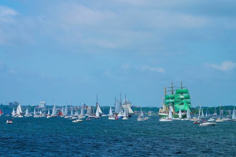 Many sailing boats on the ocean, a large sailing ship Alexander von Humbold 2 with green sails