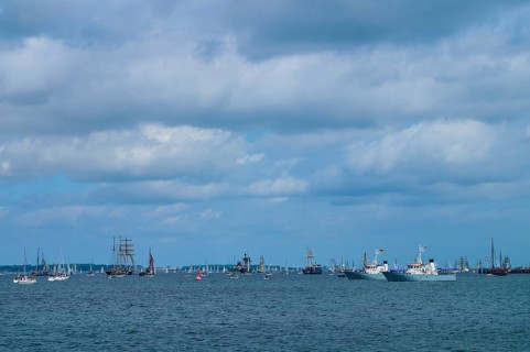 Yachts and sailing ships join each other on the sea under a cloudy sky, Windjammer Parade Kiel
