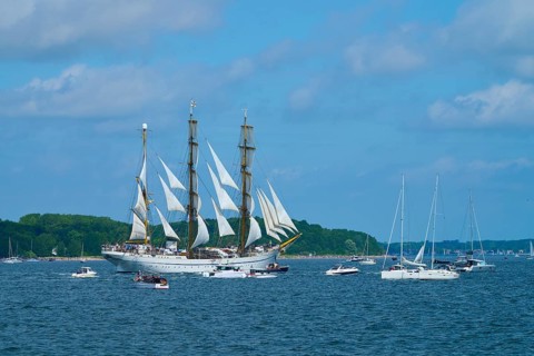 An impressive tall ship Gorch Fock with other boats on a sunny sea, Windjammer Parade Kiel 2025,
