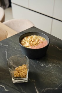 Delicious banana-strawberry smoothie served with pine nuts in a modern kitchen setting