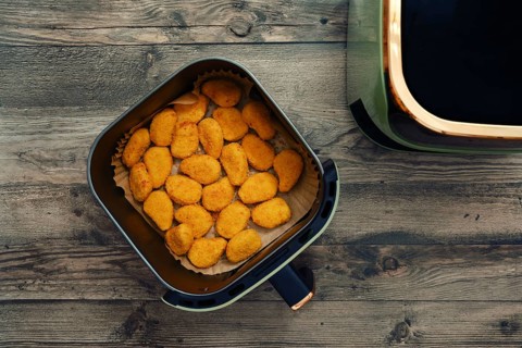 Golden and crispy chicken nuggets fill the air fryer basket, ready to be served as a tasty snack or
