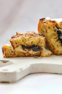 Melted cheese oozes from the sides of a perfectly toasted three cheese sandwich, showcasing a