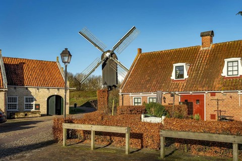 Traditional houses and windmill of the inhabited former fortress of Bourtange, Groningen,