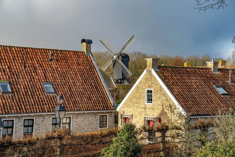 Traditional houses and windmill of the inhabited former fortress of Bourtange, Groningen,
