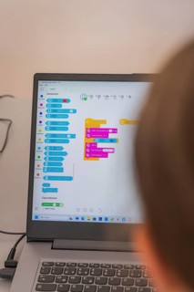Person looking at a colourful programming interface on a laptop screen, Youth Research Centre