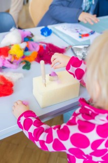 Creative moment: Child tinkering with colourful wool and tools, Youth Research Centre