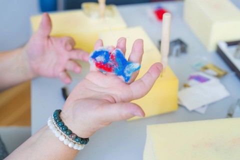 Person holding a colourful piece of foam while crafting with different materials, Youth Research