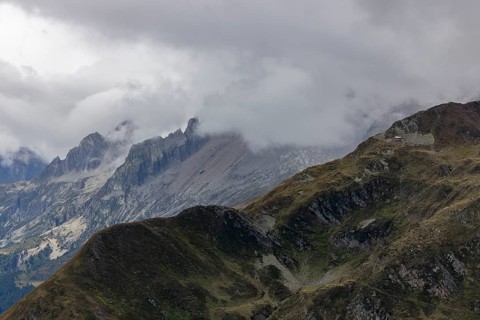 View over the Tremola to the Poncione di Fieud, the peaks of the Bedretto in the clouds, Passo
