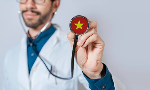 Doctor holding stethoscope with Vietnam flag. Vietnam health and care concept, Vietnam flag on
