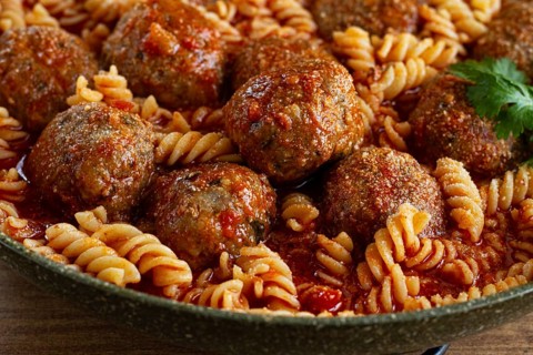 Minced meat meatballs, in tomato sauce, with fusilli pasta, in a cast-iron pan, homemade, no people