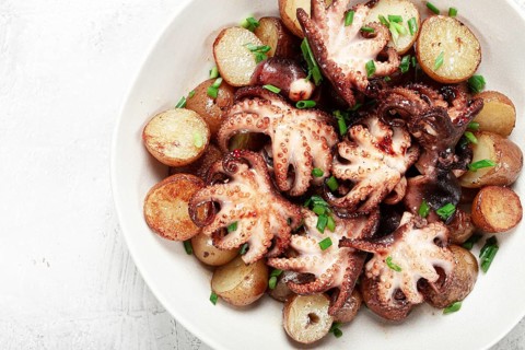 Baby grilled octopus with golden baked potatoes and fresh herbs, Maltese cuisine, homemade, no