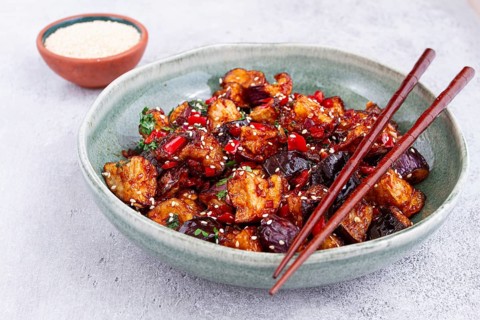 Fried eggplant, Chinese style, in sweet and sour sauce, with pepper and sesame seeds, in a green