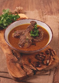 Fesenjan, an Iranian dish, stewed chicken, in a nut-pomegranate sauce, in a bowl, homemade, no