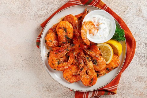Fried white-footed shrimp, tiger prawns vannamey, on a plate, with lemon and herbs, no people
