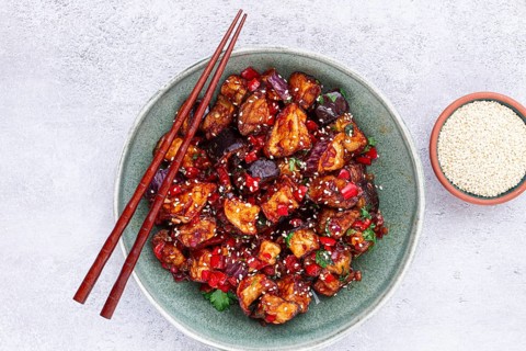 Fried eggplant, Chinese style, in sweet and sour sauce, with pepper and sesame seeds, in a green