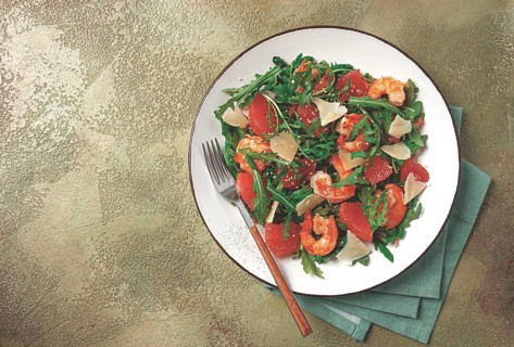Fresh shrimp salad with arugula, grapefruit, and parmesan served in a bowl