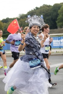A runner with the flag of the People's Republic of China on the Great Star at the 51st BMW Berlin