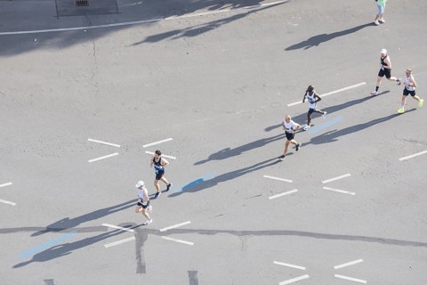 Runners with long shadows on the big star seen from the Victory Column at the 51st BMW Berlin