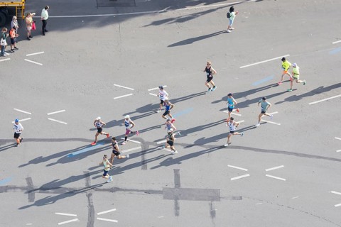 Runners with long shadows on the big star seen from the Victory Column at the 51st BMW Berlin