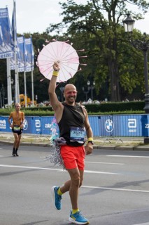 A runner with an umbrella on the Großer Stern at the 51st BMW Berlin Marathon 2025 on 21 September
