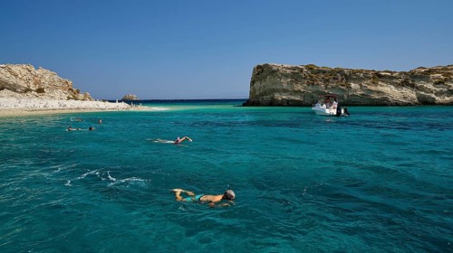 People swimming in the open sea, a boat approaches the rocks, White Cliffs, White Beach, Makri