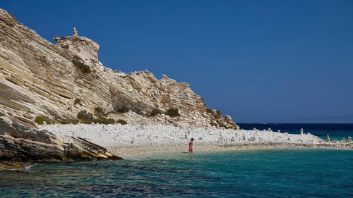 A rocky coastline with clear turquoise waters under a clear blue sky, White Cliffs, White Beach,