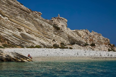 A rocky coastline with clear views of turquoise waters and a blue sky, White Cliffs, White Beach,