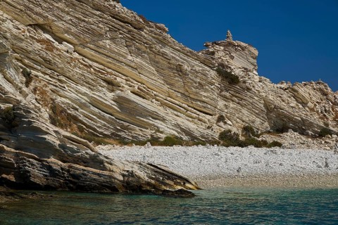 Rock formations over a calm turquoise sea with a clear sky above, White Cliffs, White Beach, Makri